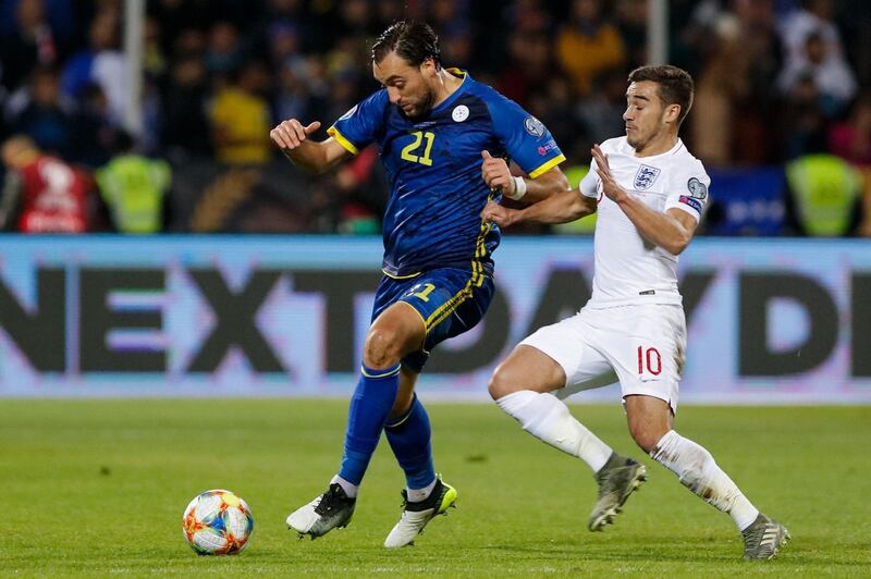 Kosovo forward Atdhe Nuhiu vies for the ball with England's midfielder Harry Winks. AFP