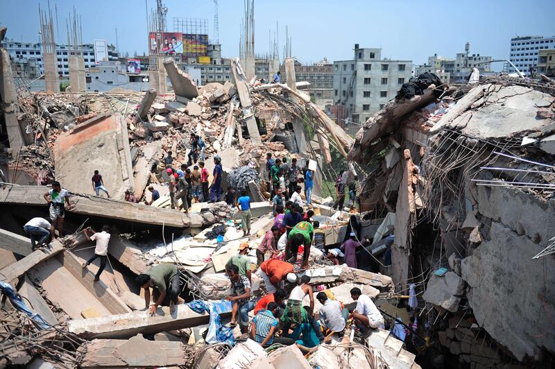 Bangladeshi civiliant volunteers assist in rescue operations after an eight-storey building collapsed in Savar, on the outskirts of Dhaka, on April 24, 2013. At least 15 people were killed and many more feared dead when an eight-storey building housing a market and garment factory collapsed in Bangladesh on Wednesday, officials said.  AFP PHOTO/Munir uz ZAMAN
 *** Local Caption ***  978721-01-08.jpg