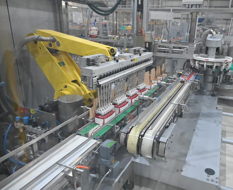 A machine transfers the packaged KitKats to a new conveyor so they can be taken to another area, where they will be boxed up. 