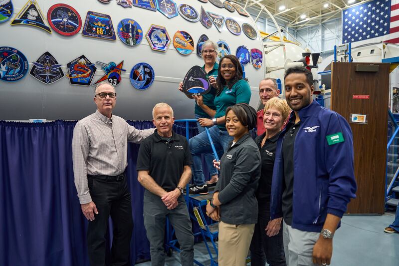 The crew hang patches celebrating their mission before the launch