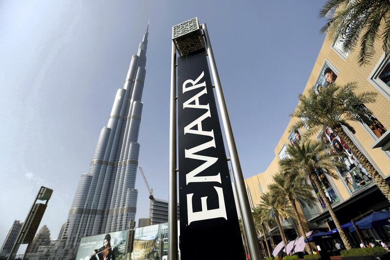 An Emaar Properties PJSC sign stands beside billboards promoting the Opera district developments near the Burj Khalifa tower in Dubai, United Arab Emirates, on Friday, Nov. 7, 2014. Dubai invested billions of dollars to become a regional trade, tourism and financial hub although it doesn't have a substantial oil revenue like fellow Gulf Arab sheikhdoms. Photographer: Chris Ratcliffe/Bloomberg