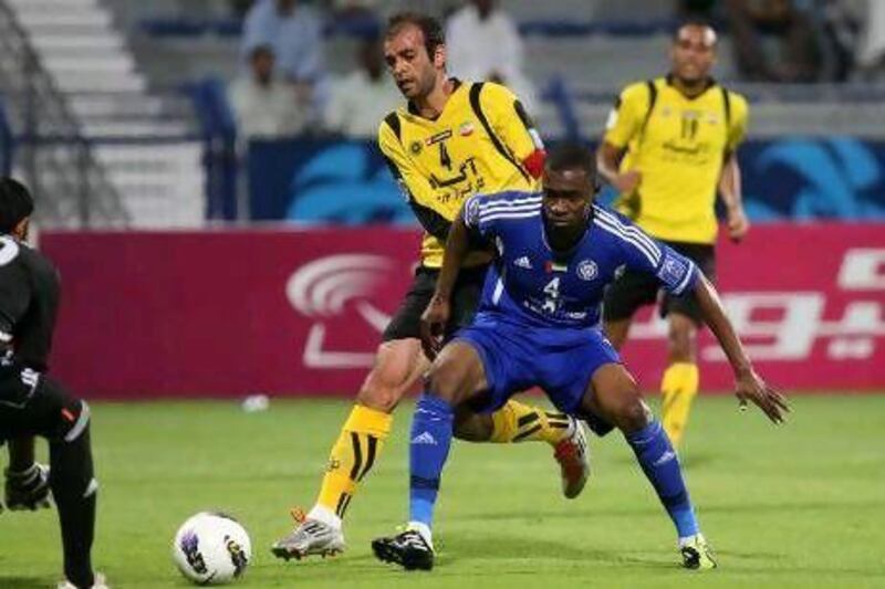 Helal Saeed, in blue, the Al Nasr defender, blocks Moharram Navidkia of Sepahan from getting to the ball before the Nasr goalkeeper last night in Dubai. Pawan Singh / The National