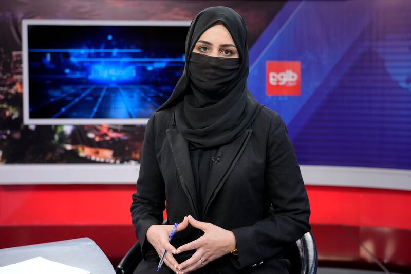 Afghan TV anchor Khatereh Ahmadi wears a face covering as she reads the news on the TOLOnews channel in Kabul on May 22, 2022. AP