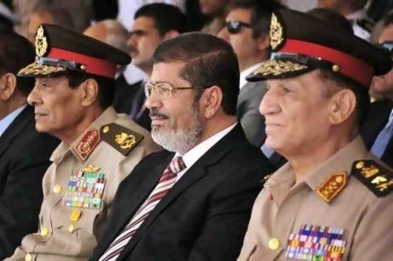 Mohammed Morsi (centre) has been hampered by the influential military, which has made a series of moves to try curtail both his power and that of the Islamist-dominated parliament, but he has shown his teeth in recent weeks by targeting elements of the media and by firing several officials.