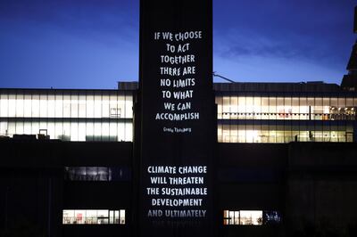 The Tate Modern museum chimney is seen illuminated with a quote by Greta Thunberg, during an installation called 'Hurt Earth' by artist Jenny Holzer, projecting quotes from more than 40 climate activists and leaders, in London on October 30, 2021. Reuters 