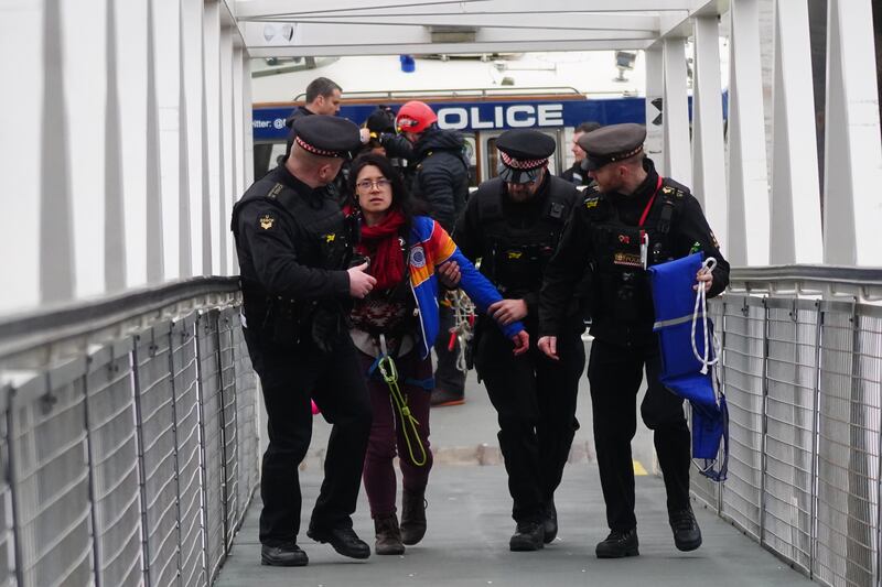 Police officers with an activist from Extinction Rebellion. PA