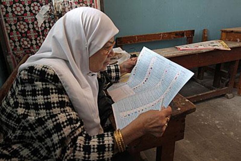 An Egyptian woman studies her ballot paper in a polling station in Cairo on Sunday during the first round of the Shura Council elections.