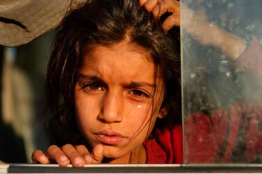 A Syrian girl who fled the Turkish offensive into northern Syria weeps as she sits in a bus after arriving at the Bardarash camp, north of Mosul in Iraq. The camp used to host Iraqis displaced from Mosul during the fight against ISIS and was closed two years ago. AP Photo