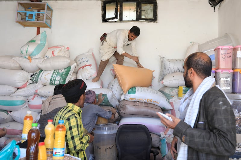 Yemenis try to buy grain at a market in Sanaa on Monday. The escalation of Houthi attacks on shipping lanes in the Red Sea and the Gulf of Aden could put further pressure on food prices. EPA