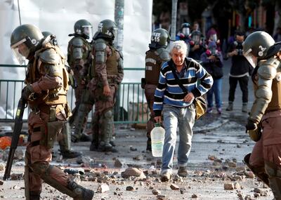 An elderly man crosses a street as demonstrators clash with police during a protest against Chile's government in Valparaiso, Chile November 18, 2019. REUTERS/Goran Tomasevic     TPX IMAGES OF THE DAY