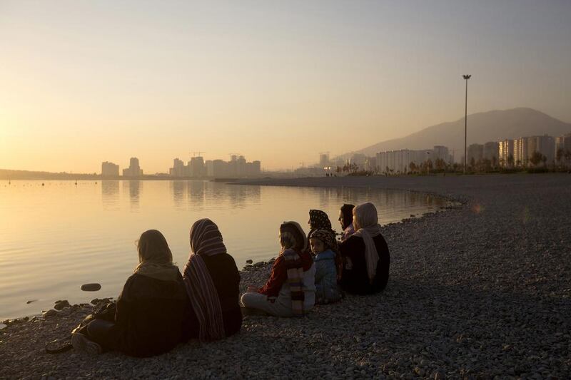 A group of women sit on the shore of an artificial lake in Chitgar Park, north-west of Tehran (Photographer: Simon Dawson/Bloomberg)