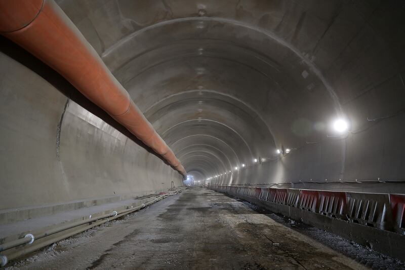 A circular scaffold frame painstakingly moves through the tunnel, allowing workers to operate safely through the walls of the snaking shaft of T1.