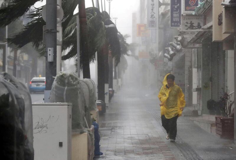 A passer-by walks in heavy rain and wind caused by Typhoon Trami in the prefectural capital Naha, on the southern island of Okinawa. Kyodo/Reuters