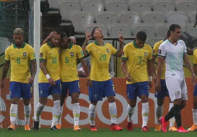 Brazil's Roberto Firmino (C) celebrates with teammates after scoring. AFP