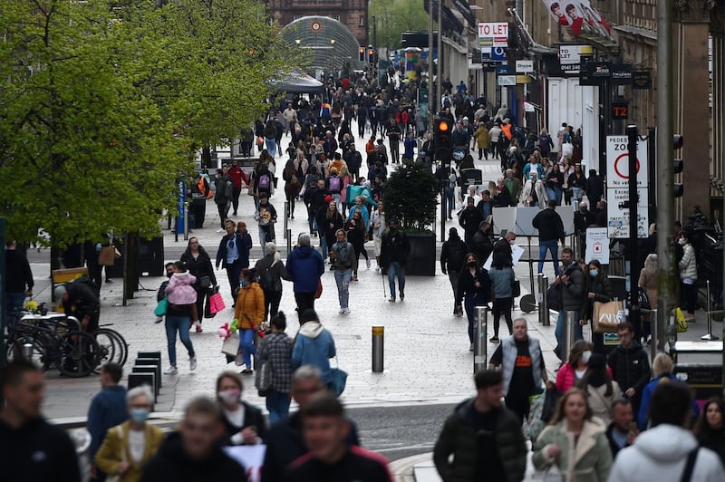 Pedestrians walk past reopened shops and businesses in Glasgow following the relaxing of some Covid-19 restrictions in Scotland, after the third national lockdown. AFP