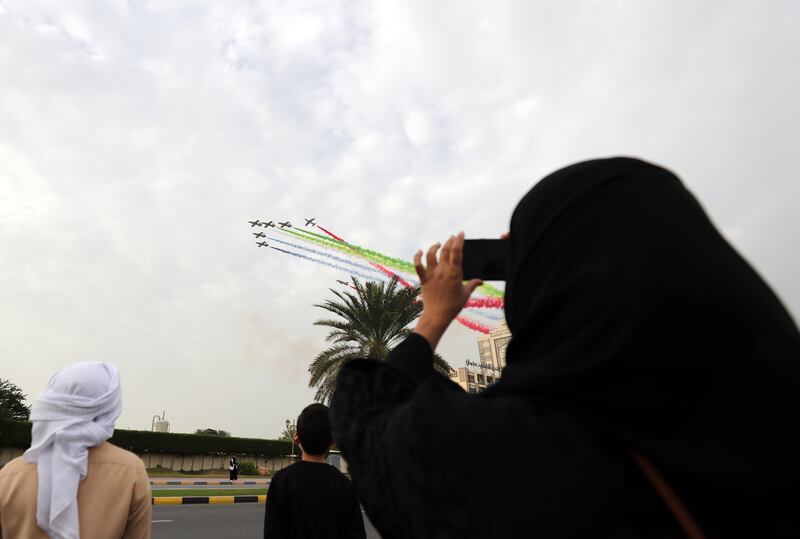 People watch as Al Fursan jets fly past the venue.