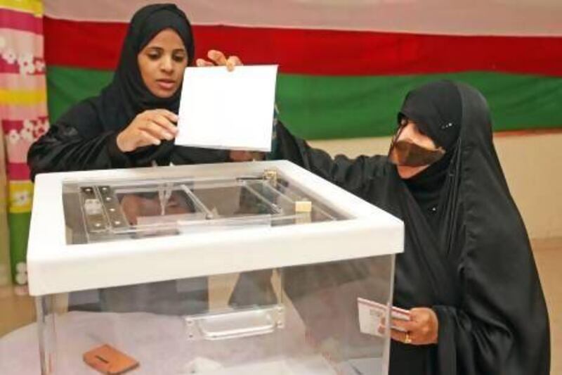 An Omani woman casts her vote at a polling station yesterday in Oman's first municipal election.
