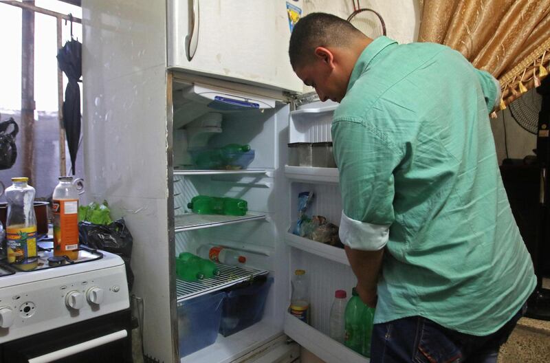 A Lebanese man displays the content of his refrigerator at his apartment in the southern city of Sidon. AFP