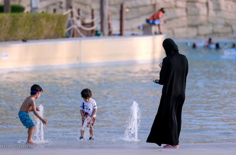 Abu Dhabi, United Arab Emirates, August 4, 2020.   Yas Waterworld Abu Dhabi opens with 30% capacity as Covid-19 restrictions slowly come to an ease.  A mother watches her sons at one of the pool areas of the waterpark.
Victor Besa /The National
Section: NA
Reporter: