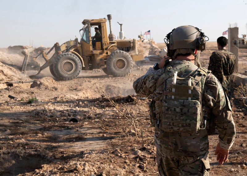 A U.S. service member watches as Syrian Democratic Forces remove military fortifications during the implementation of the security mechanism along the Turkey-Syria border in northeast Syria. AP