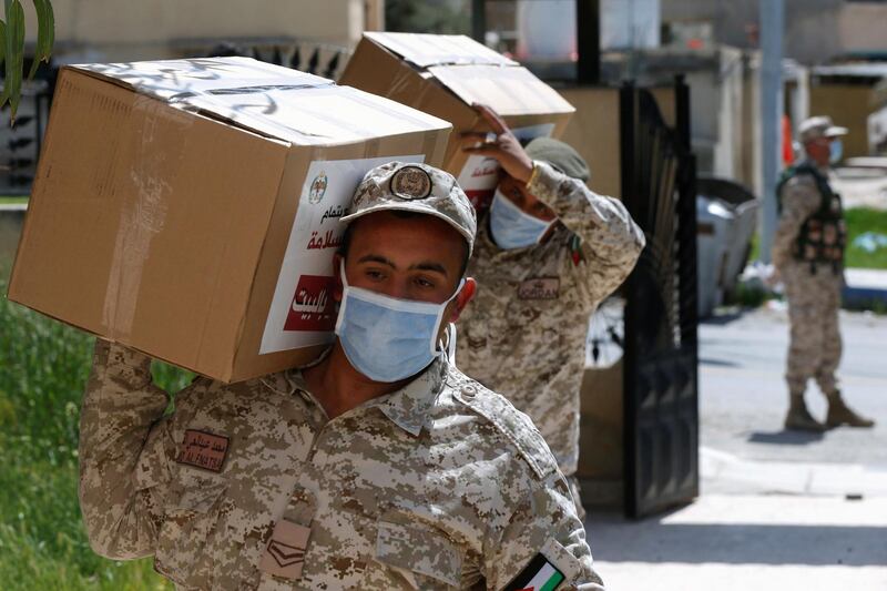 Soldiers carry food parcels to distribute to some of residents of the city of Zarqa, after the implementation of a strict lockdown, amid concerns over the spread of the coronavirus in Jordan. Reuters