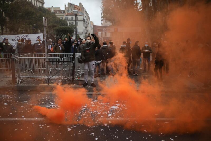 Protestors toss plates at a demonstration against restaurant and bar closures in Marseille, southern France. AP Photo