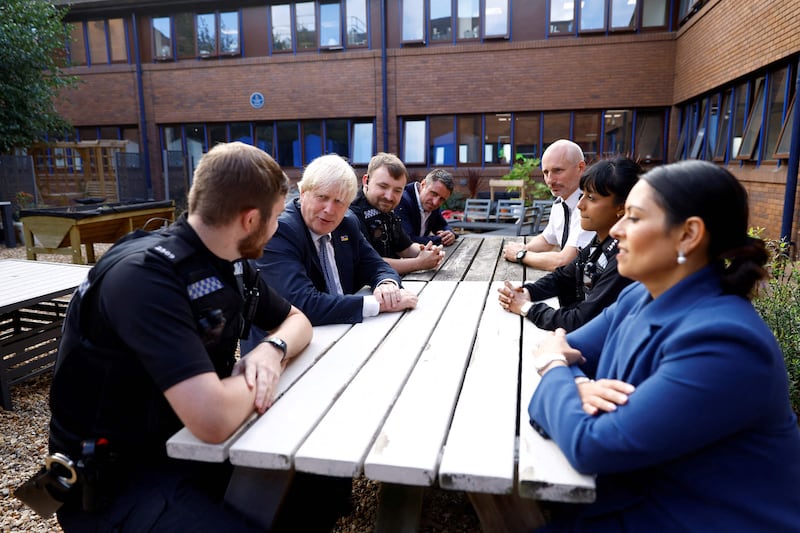 Mr Johnson and Britain's Home Secretary Priti Patel meet newly-recruited officers at Milton Keynes Police Station. AFP