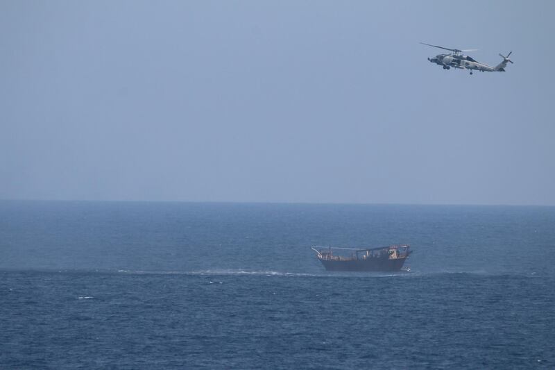 An SH-60 Seahawk helicopter assigned to the United States guided-missile cruiser USS Monterey (CG 61)(not shown) flies above a stateless dhow interdicted with a shipment of illicit weapons in international waters of the North Arabian Sea in this picture taken on May 6, 2021 and released by U.S.Navy on May 9, 2021. U.S. Navy Forces Central Command/U.S. Navy/Handout via REUTERS ATTENTION EDITORS- THIS IMAGE HAS BEEN SUPPLIED BY A THIRD PARTY.