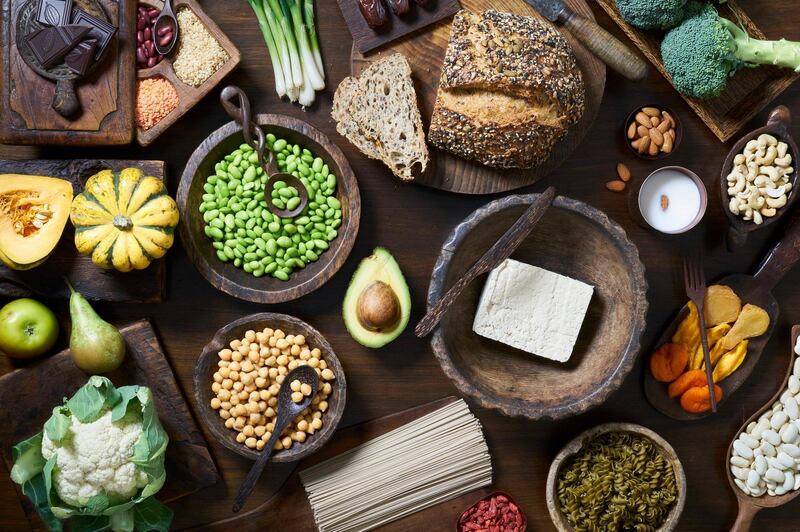 Overhead shot of healthy vegan food including fruit vegetables tofu and beans. Getty Images