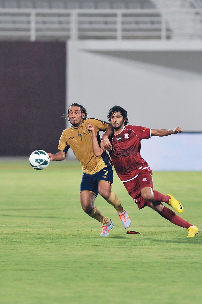 Richard Porta of Dubai fights for the ball with Al Wahda's Salem Saleh.  Azeem Shaukat / Al Ittihad