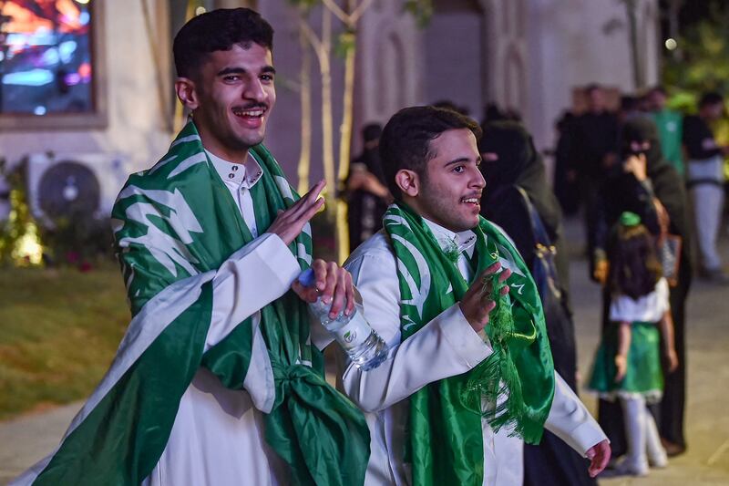 Football fans draped in Saudi Arabia's flag take part in celebrations in Riyadh. AFP