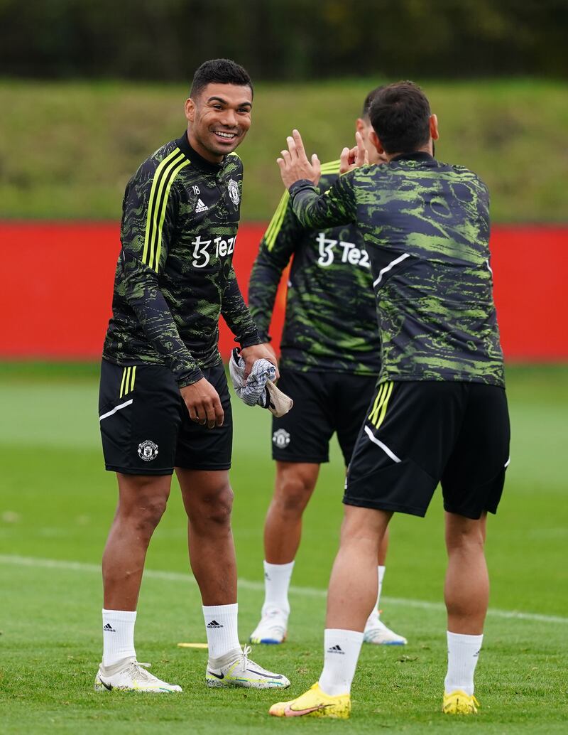 Manchester United's Casemiro jokes with Bruno Fernandes during training. PA