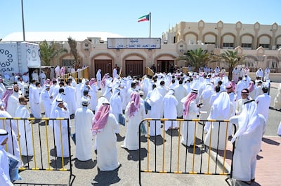 People wait to cast their votes in Kuwait City, on Thursday. EPA
