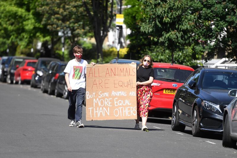 LONDON, UNITED KINGDOM - MAY 25:  Protesters hold a banner which reads 'All animals are equal but some animals are more equal than others' (a quote from George Orwell's Animal Farm) outside the home of Dominic Cummings, Chief Advisor to Prime Minister Boris Johnson, on May 25, 2020 in London, England. Yesterday, British Prime Minister Boris Johnson defended his chief adviser during a press conference amid mounting calls for him to be sacked, after it emerged he had travelled hundreds of miles from his North London Home to his parent‚Äôs house in Durham while the country was on lockdown.  (Photo by Peter Summers/Getty Images)