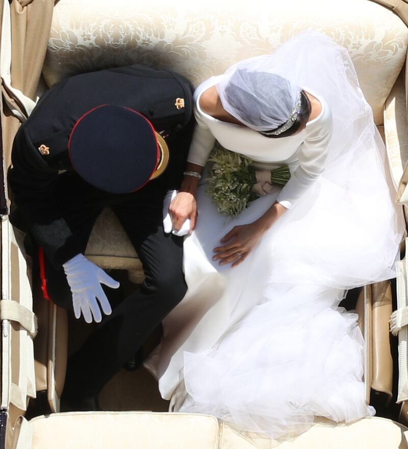 WINDSOR, ENGLAND - MAY 19: Prince Harry, Duke of Sussex and the Duchess of Sussex hold hands in the Ascot Landau Carriage as their carriage procession rides along the Long Walk, on May 19, 2018 after their wedding ceremony.  (Photo by Yui Mok - WPA Pool/Getty Images)