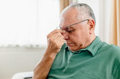 A Distraught Senior Man Suffering From a Migraine