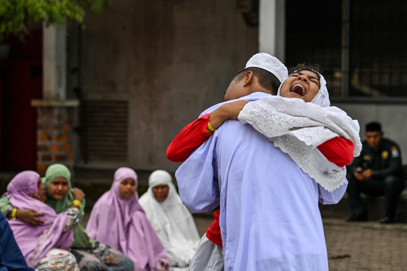 Rohingya refugees from Myanmar embrace after Eid prayers at a shelter in Meulaboh, Indonesia. AFP