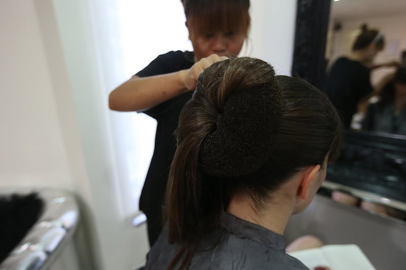 3 - June - 2013, GLAMOUR Hair Salon, Abu Dhabi

4. Putting the hair over the bun and thing and pinning it in place

How to make a big bun on our own. Fatima Al Marzooqi/ The National.
