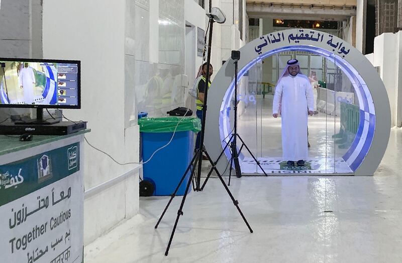 A man passes through a self-sterilisation gate set up at an entrance of the Kaaba and the Grand Mosque, as a preventive measure amid the the COVID-19 pandemic during the Muslim  month of Ramadan in the Saudi holy city of Mecca.  AFP