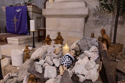 A Nativity scene in the Evangelical Lutheran Christmas Church in Bethlehem depicts the infant Jesus wrapped in a keffiyeh amid a pile of rubble. Getty