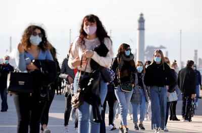 People wearing protective face masks walk near the beach in Dunkirk as the government eyes new measures to limit the spread of COVID-19 in the region, France, February 24, 2021. REUTERS/ Pascal Rossignol