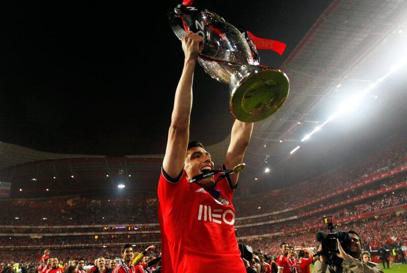 Benfica's Oscar Cardozo, from Paraguay, lifts the trophy celebrating after beating Olhanense on Sunday at Estadio da Luz. Benfica's 2-0 clinched them the Portuguese Primeira Liga championship. They will play Juventus in the the first leg of their Europa League semi-final tie on Thursday April 24. Francisco Seco / AP / April 20, 2014
