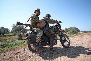 Turkish-backed rebels carry a defused anti-tank mine as they ride their motorcycle in the village of Al Nayrab, about 14 kilometres southeast of the city of Idlib in northwestern Syria after seizing it from regime forces. AFP