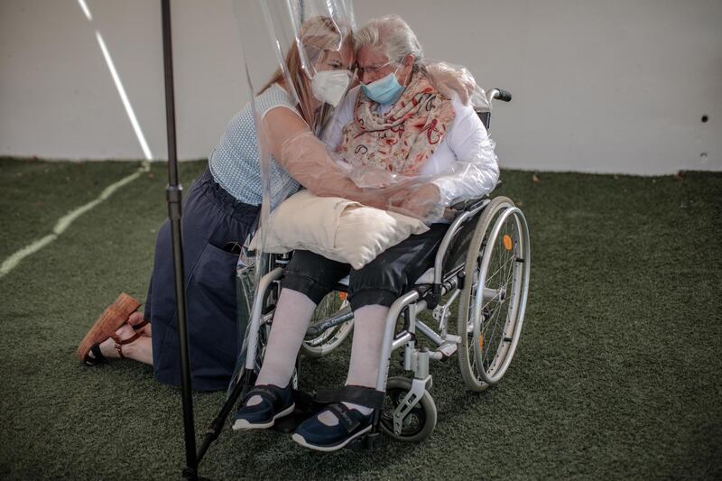 A woman embraces her mother through a plastic device after three months without a hug at a home for the elderly in Valencia, Spain.  EPA
