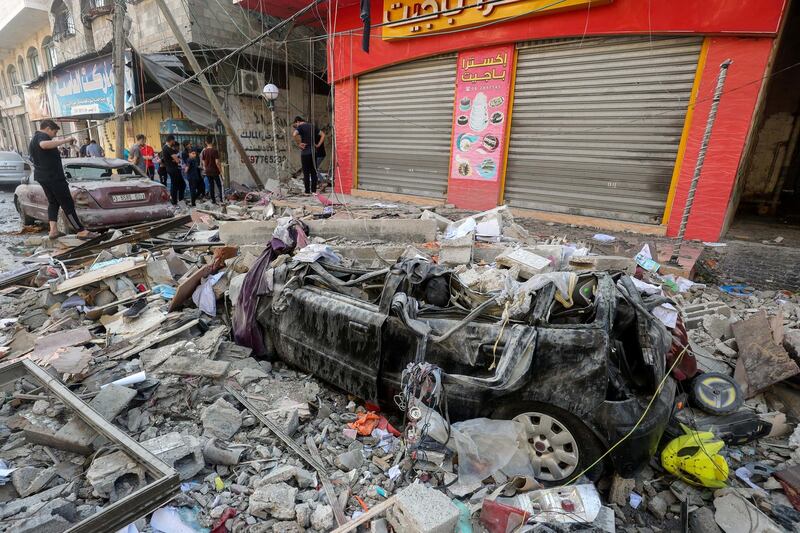 Palestinians stand near the damage in the aftermath of an Israeli air strike on a house in Gaza city. Reuters