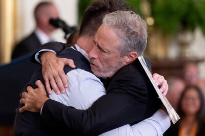 Former 'Daily Show' host and activist Jon Stewart hugs Sri Benson at the signing ceremony of the Pact Act. EPA