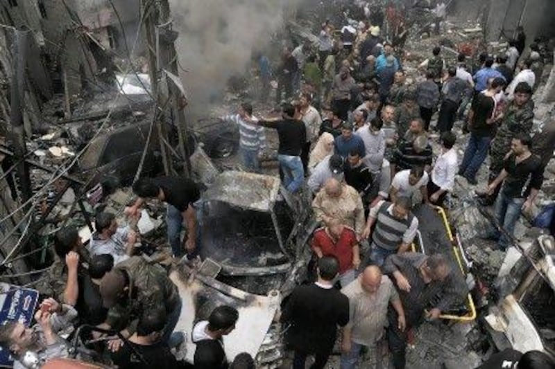 Syrians inspect the site of an explosion in the Mazzeh district of the capital Damascus yesterday.  At least 11 people were killed and dozens wounded in the attack, Syrian state television reported.