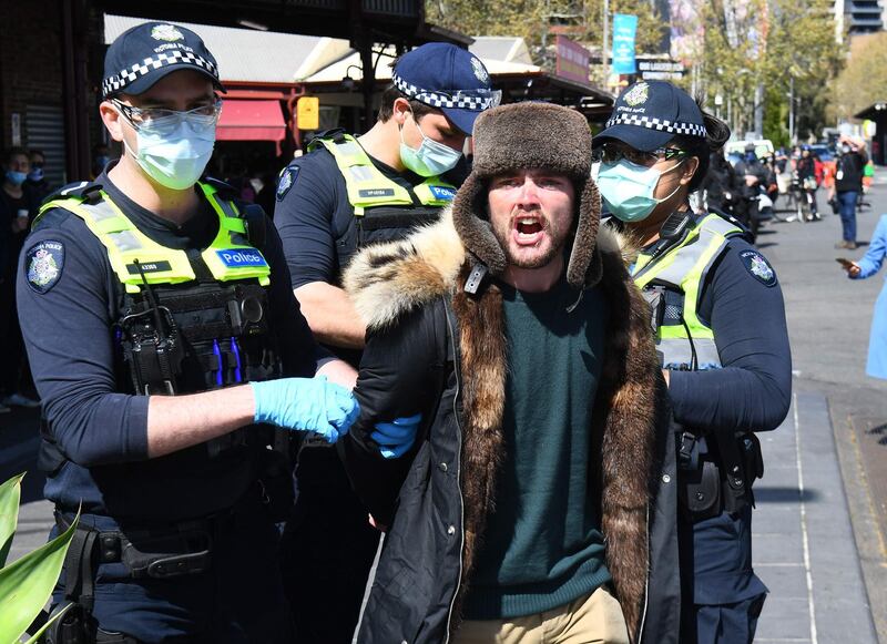 Police detain an anti-lockdown protester at Melbourne's Queen Victoria Market during a rally, amid the ongoing COVID-19 coronavirus pandemic. Melbourne continues to enforce strict lockdown measures to battle a second wave of the coronavirus. AFP