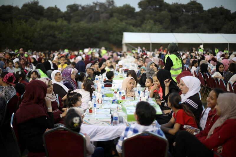 Orphans wait to eat their iftar meal at Petra Stadium in Amman, Jordan.  Reuters