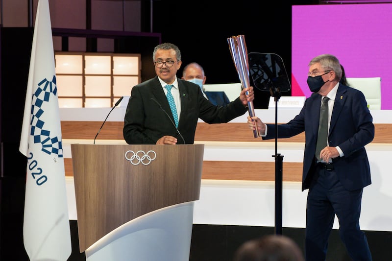 World Health Organisation Director-General Tedros Adhanom Ghebreyesus receives the Olympic torch from International Olympic Committee Presidents Thomas Bach in Tokyo. AFP